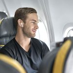 guy-on-plane-with-noise-cancelling-earbuds